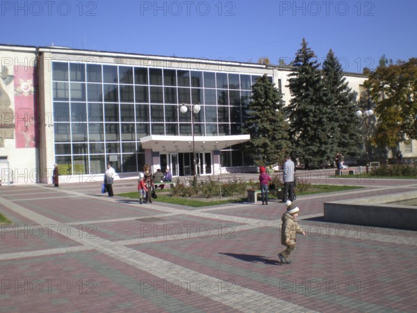 Residents of Melitopol with their children stroll through Victory Square near the Shevchenko