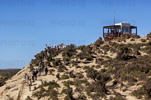 Hiker on a hill trail with views and an observation point in the blue sky, The countryside of