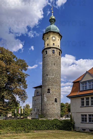Historic tower with clock under blue sky and clouds, surrounded by buildings, The Niedeck Ruins in