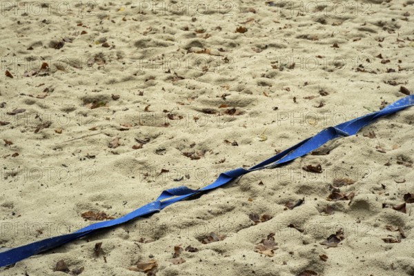 Borken-Hoxfeld, NRW, Germany, A stretch of sandy beach shows blue tape running across, marking a