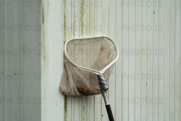 Borken-Hoxfeld, NRW, Germany, A cleaning tool leans against a dirty wall, showing signs of recent