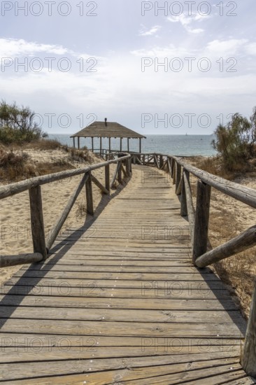 A wooden walkway leads to a cabin by the sea. View of the Atlantic Ocean from the beach of the