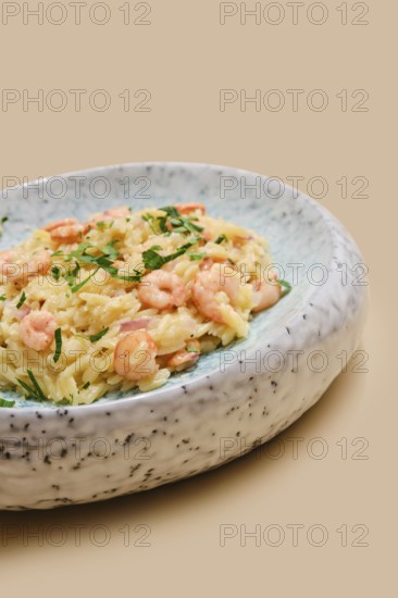 A delicious dish of risoni pasta is topped with tender shrimps and sprinkled with fresh herbs. This