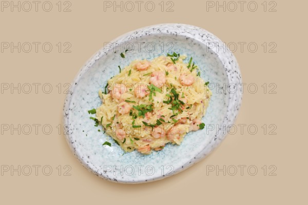 A delightful dish features risoni pasta mixed with tender shrimp and sprinkled with fresh herbs.