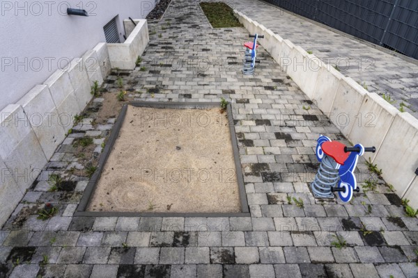 Playground at a multi-family residential building in Bochum, small sandpit, 2 spring seesaw toys,