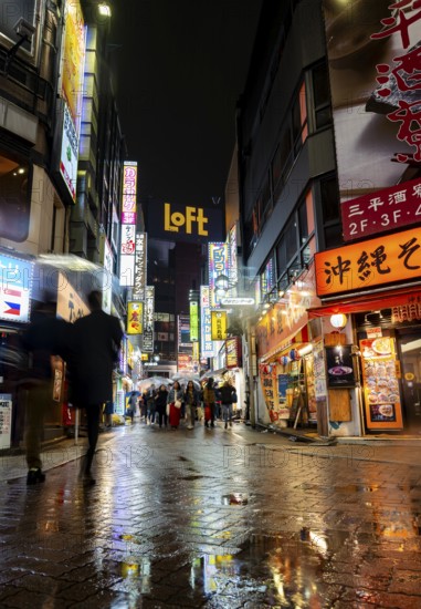 Busy pedestrian zone with many shopping centers and stores, illuminated with lots of neon signs at