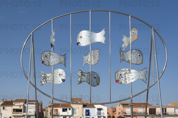 The modern metal sculpture Les Daurades Miroirs by Dominique Dore on the Plage de la Lagette shows