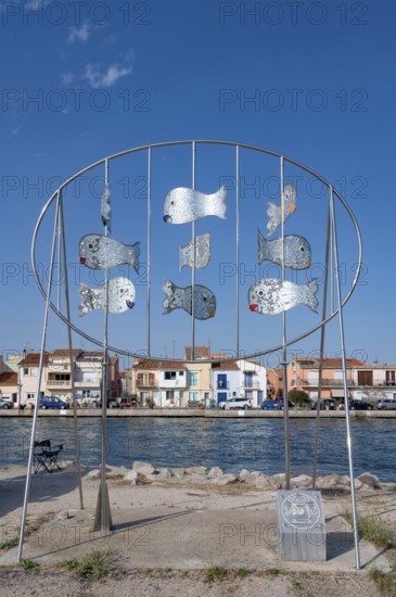 The modern metal sculpture Les Daurades Miroirs by Dominique Dore on the Plage de la Lagette shows