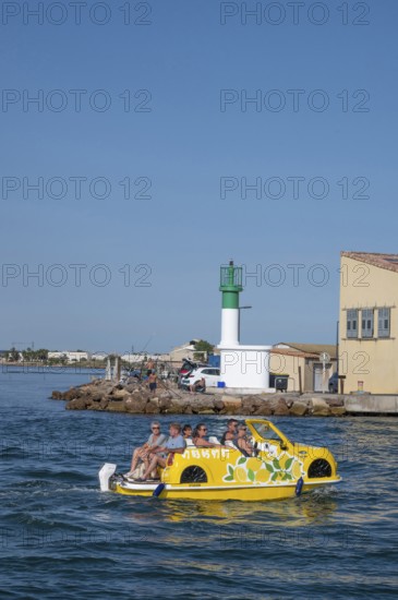 Sightseeing on the water: a yellow water car with tourists and lemon decorations rides on the Canal