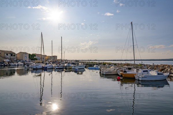 Atmospheric sun reflection on the quiet water surface of the harbor basin in La Pointe Courte, seen