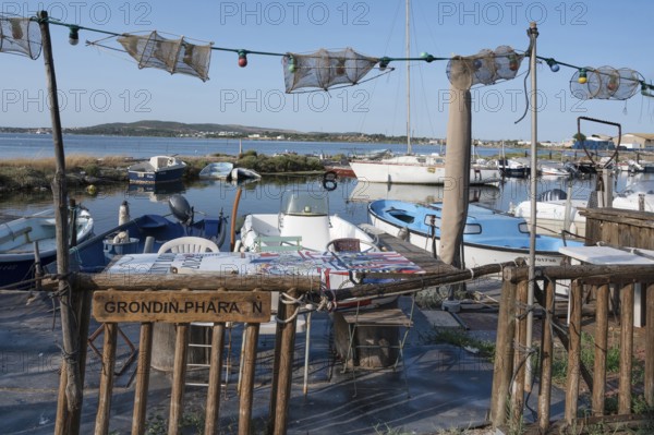 A fisherman's sitting area for an aperitif with tables and chairs as well as fishing nets as