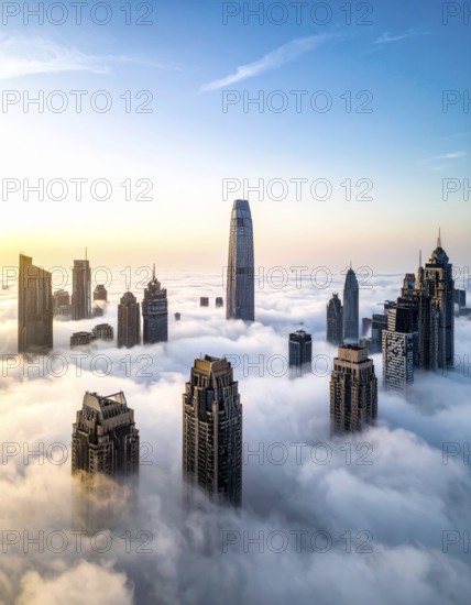 City scape emerging from a dense enveloping fog in sunrise and skyscrapers piercing the haze, big