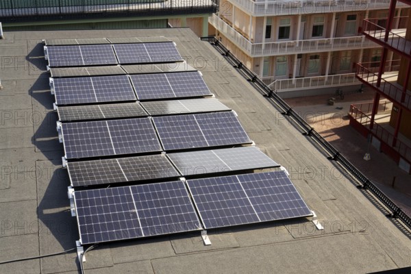 Solar panels on roof of apartment building, renewable green sustainable energy concept, water