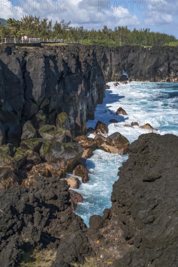 Massive, black lava cliffs rise steeply out of the Indian Ocean at Cap Mechant, where white surf