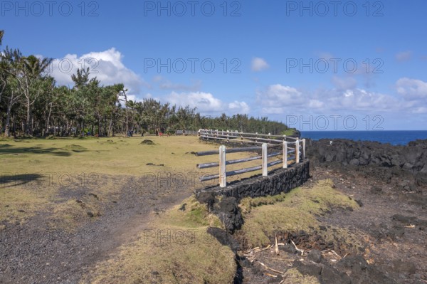A rustic wooden barrier on a black lava foundation borders the viewpoint at Cap Mechant, where the