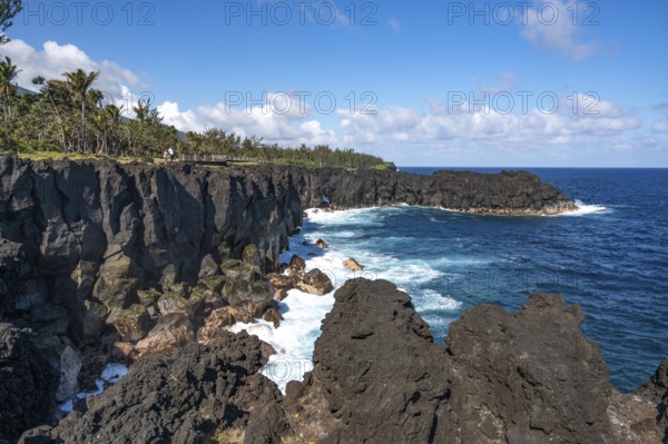Massive, black lava cliffs rise steeply out of the Indian Ocean at Cap Mechant, where white surf