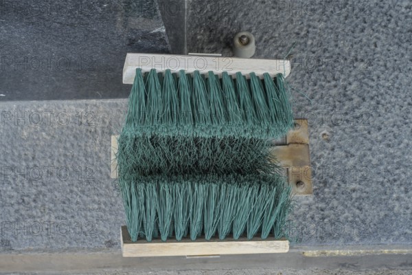Broom at the entrance to the house, device for cleaning shoes in winter, Helsinki, Finland