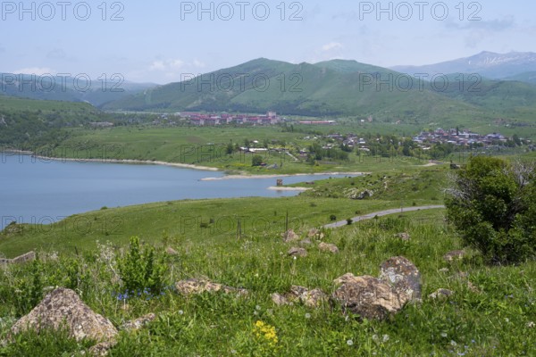 Wide view of a lake surrounded by green hills and mountains under a blue sky, Kechut, Kushchi,