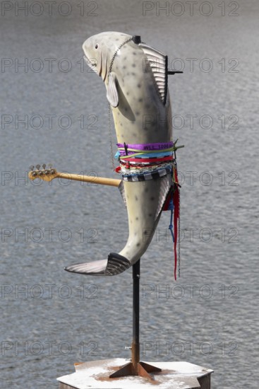 Fish sculpture with guitar, art installation What If They Bark by conceptual artist Cosima von
