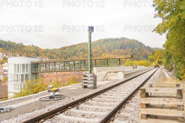 Railway tracks on a viaduct surrounded by autumn trees and buildings, signal building on the