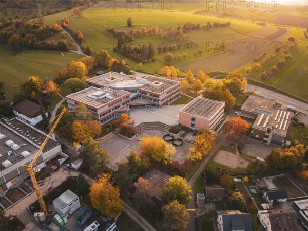 Modern Maria von Linden Gymnasium school building in autumn landscape at sunset, captured by drone,