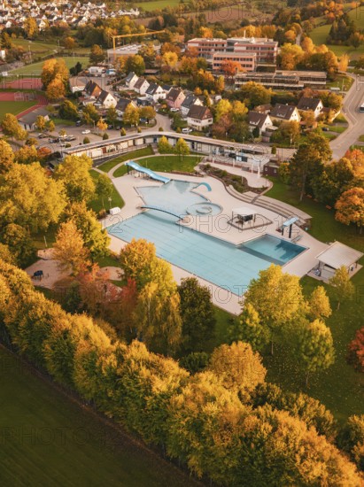 Aerial view of an outdoor pool in an autumn setting with colorful trees, Calw, Black Forest,