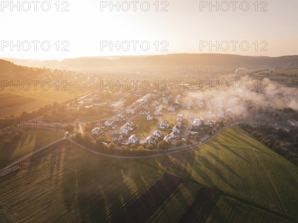 A small town surrounded by fields at sunrise with enchanting fog, Calw Stammheim, Black Forest,