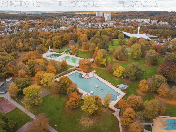 A swimming pool surrounded by autumn trees, nestled in a large park, Sindelfingen, Böblingen