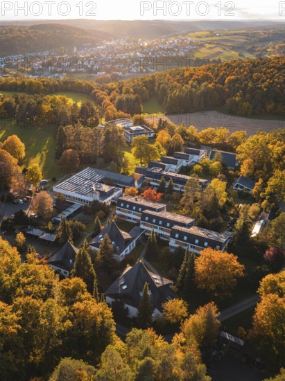 Sunlight illuminates motherhouse buildings and autumn trees in rural surroundings, Aidlingen,