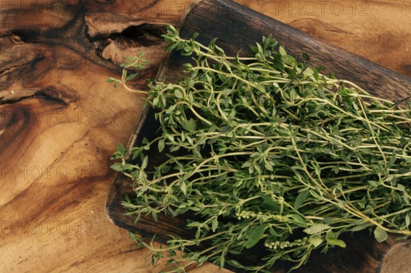 Fresh thyme sprigs on wooden cutting board ready for cooking and seasoning dishes