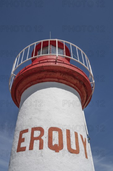 An extreme bottom view shows the upper, cylindrical part of the white-red lighthouse of Erquy,