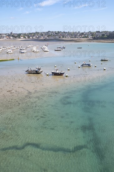 Over the shallow, turquoise water and moist sandy soil at low tide (low tide), with the shadows of