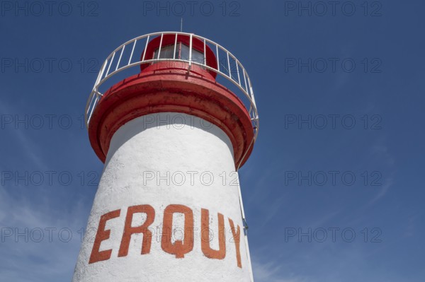 An extreme bottom view shows the upper, cylindrical part of the white-red lighthouse of Erquy,