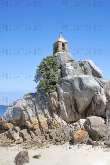 The small, historic Saint-Gildas chapel is perched on rugged, pink rock formations on the banks of