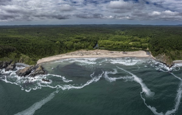 Panoramic view of a beach with crashing waves and dense forests. Aerial view to beautiful Silistar