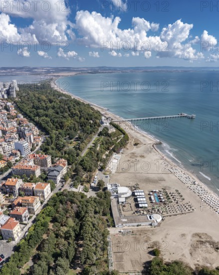 City beach with a long pier extending into the ocean. Aerial view to bech and sea garden of Burgas,