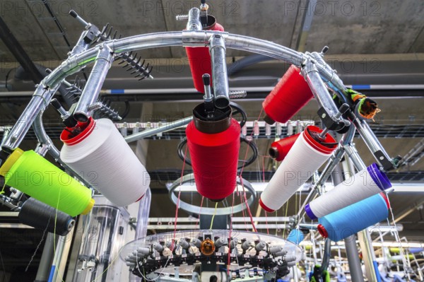 Colorful reel thread set up at modern and automatic sewing or embroidery spinning machine, textile