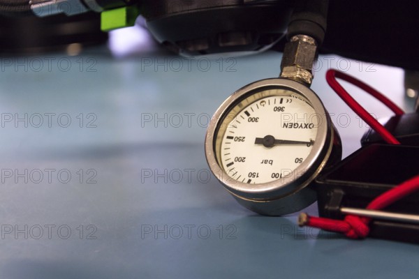 Gas pressure indicator, scuba diving oxygen lying on blue table background, copy space Prague Czech