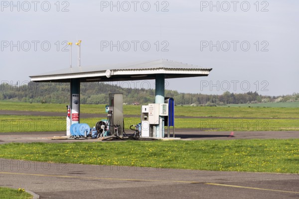 Aviation fuel filling station on airport with airfield runway in background on a sunny spring day