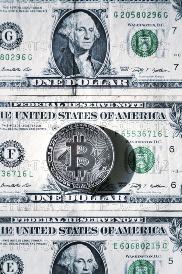 Silver bitcoin coin lying on United States dollars, cryptocurrency concept Prague Czech republic