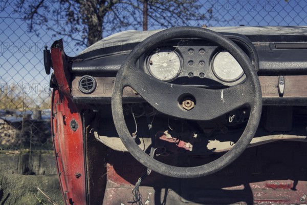 Filtered vintage photo of steering wheel and rusty speedometer on car control panel Prague Czech