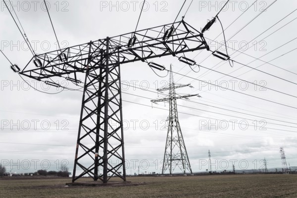 Electricity pylons conducting current from distribution power station, solar renewable energy and