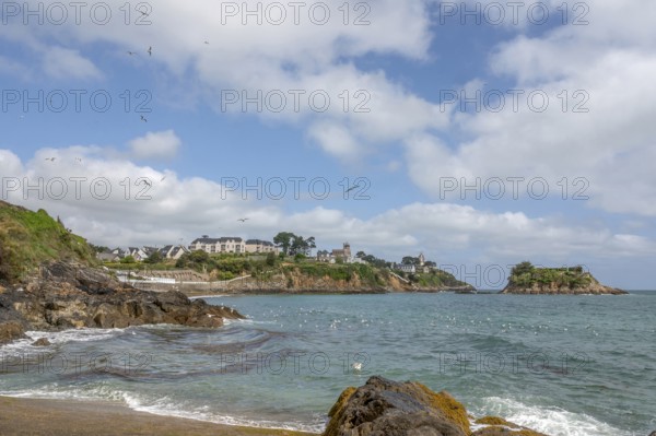 The rocky bay of the Plage de la Comtesse with turquoise water, bordered in the background by a