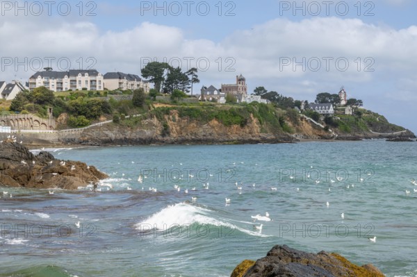 The rocky bay of the Plage de la Comtesse with a little wave wave in the turquoise water, which is
