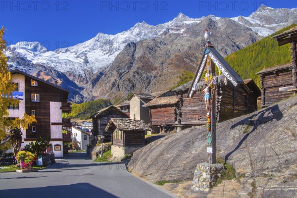 Saas wayside shrine with typical granaries on the outskirts of the village with Alphubel 4206m and