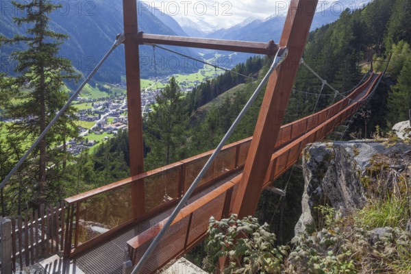 View of Neustift and Stubai Glacier from suspension bridge on the Sunnenseit'n-Weg hiking trail in