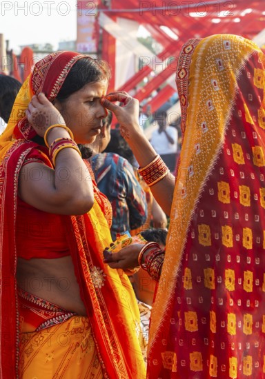 Hindu devotees gather on the banks of the Brahmaputra River to offer prayers to the Sun God on the