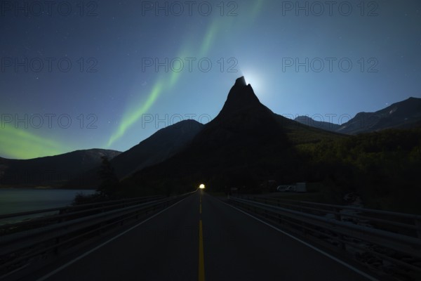 National mountain of Norway, Stetind in the Nordland under auroras and a full moon. On the road