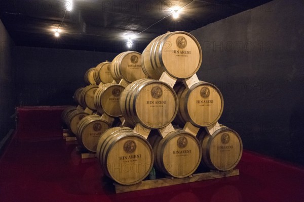 Many stacked wine barrels in a cellar with dim lights, Hin Areni Winery, Areni Village, Vayots Dzor
