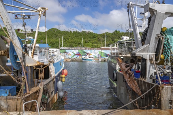 Two large, rusty fishing boats in the Port du Legue harbour at the mouth of the Legue. In the